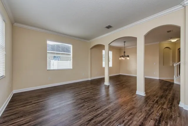 a view of a room with wooden floor staircase and a living room