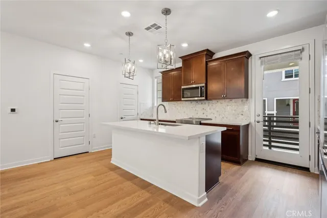 a large kitchen with kitchen island a sink stainless steel appliances and cabinets