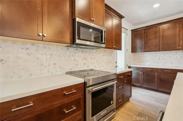 a kitchen with stainless steel appliances granite countertop a stove microwave and sink