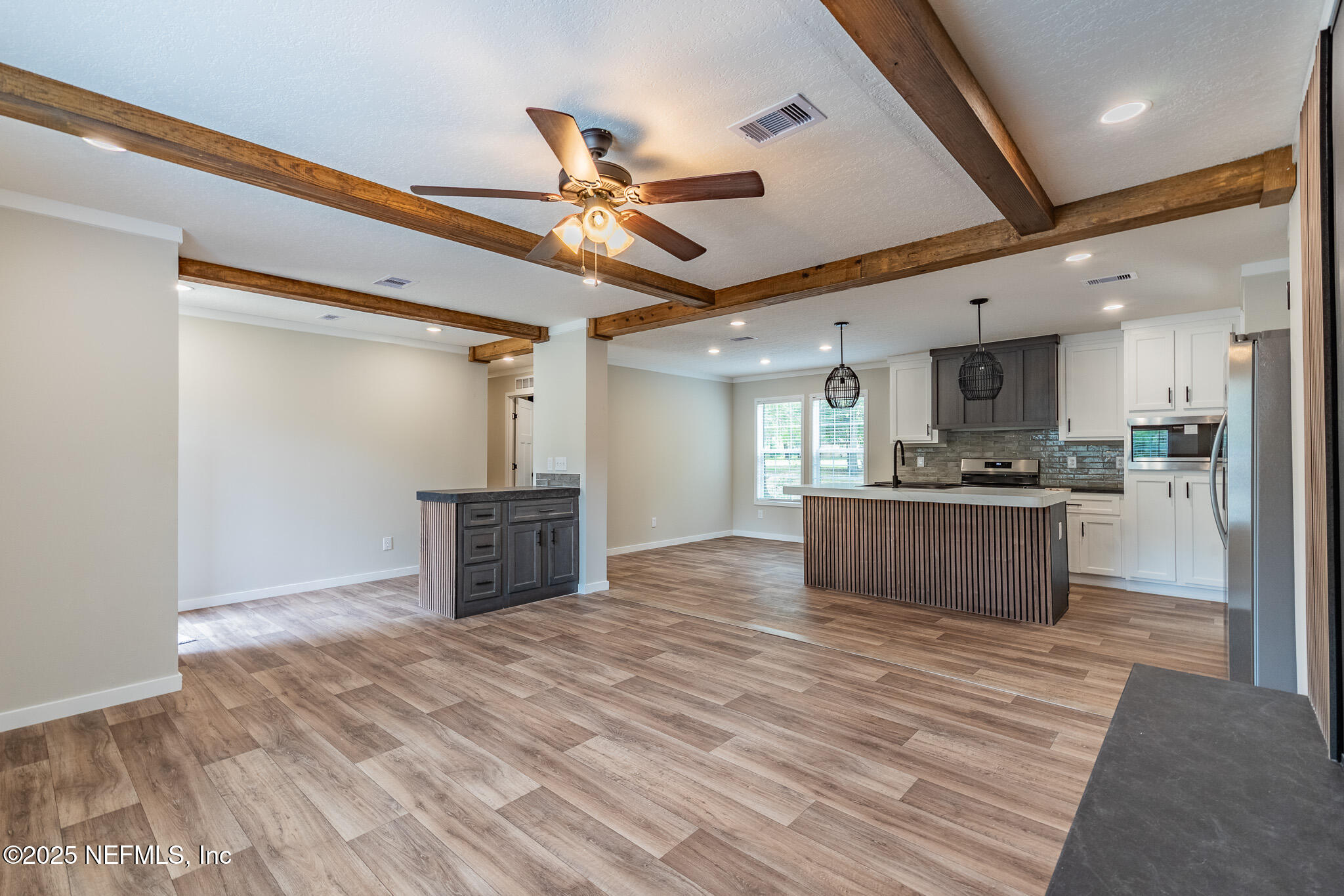 54405 Lee Stoner Road East Callahan, FL 32011 - Photo 5 of 24 a large kitchen with stainless steel appliances kitchen island granite countertop a refrigerator a stove and a sink with granite countertops