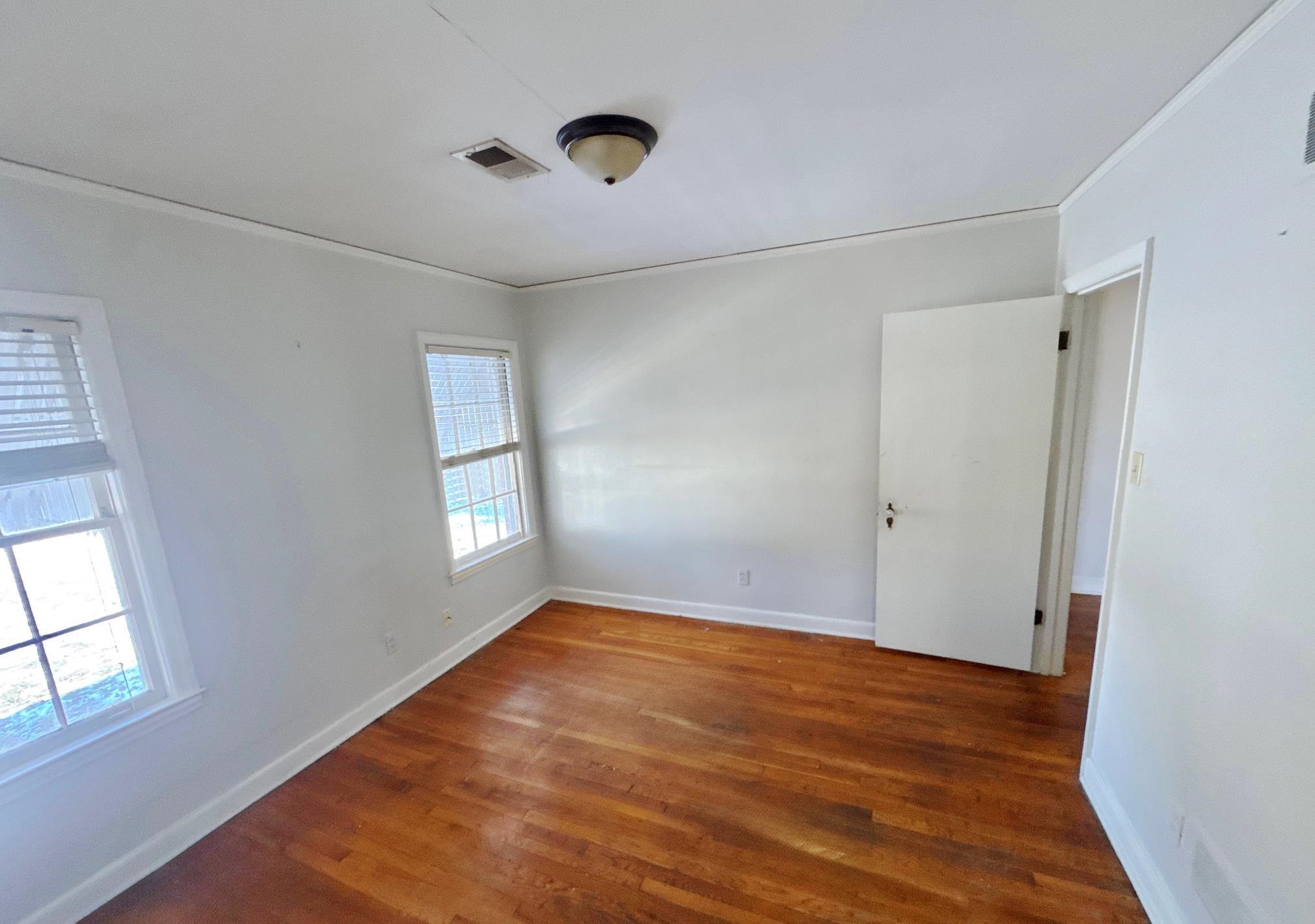1454 Railton Road Memphis, TN 38111 - Photo 5 of 10 an empty room with wooden floor and windows