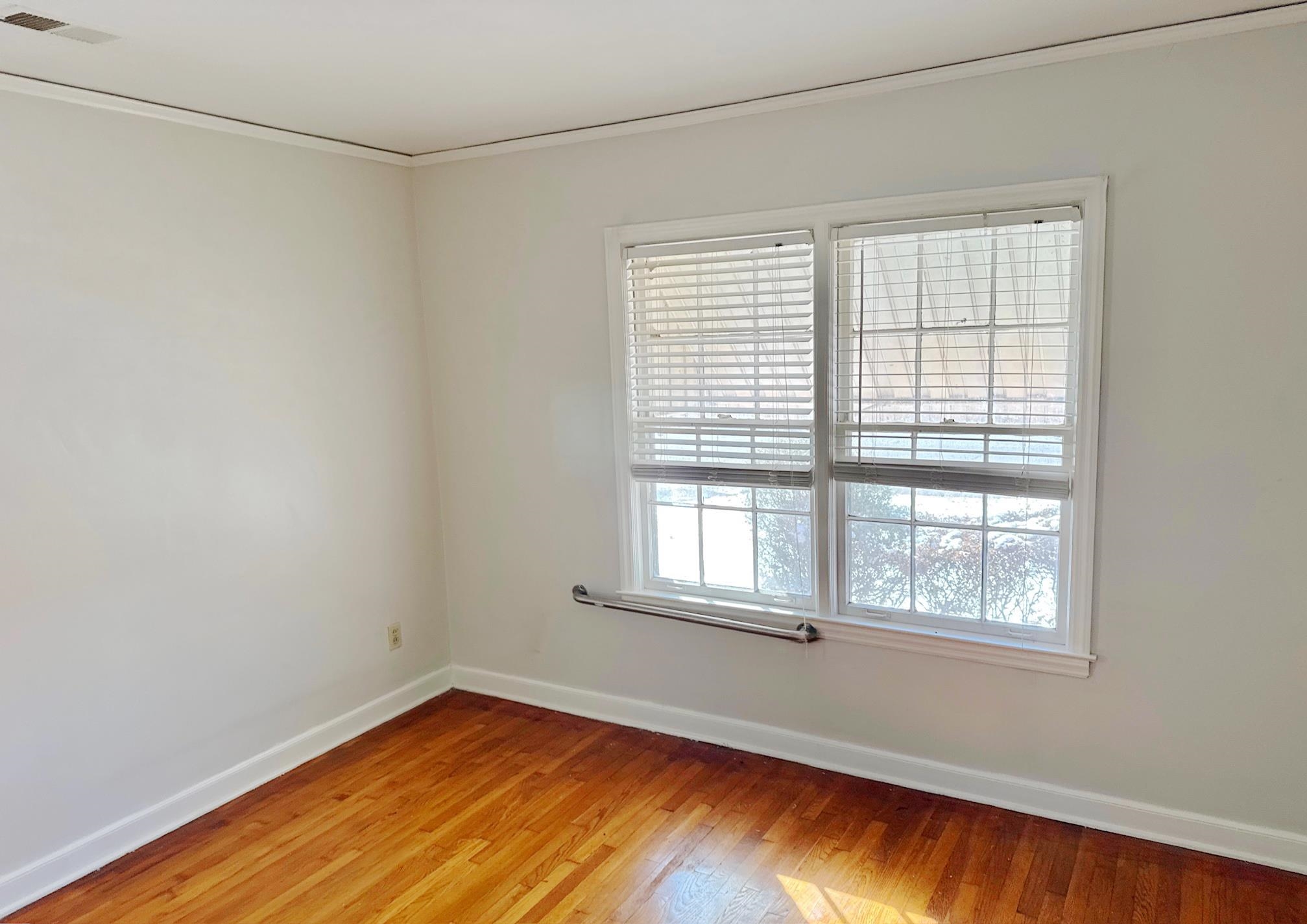 1454 Railton Road Memphis, TN 38111 - Photo 7 of 10 a view of an empty room with wooden floor and a window