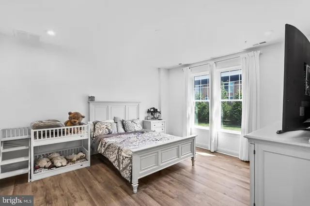 a bedroom with a bed and a flat tv screen on the dresser