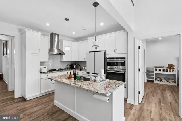 a kitchen with kitchen island a stove a sink and a refrigerator