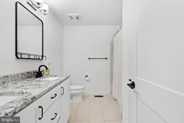a bathroom with a granite countertop sink toilet and shower