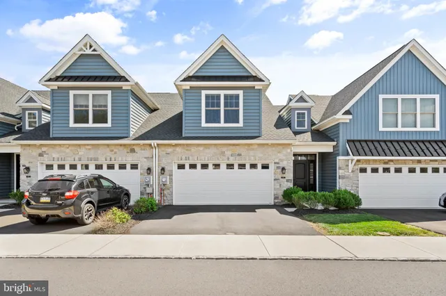 a front view of a house with a garden and parking