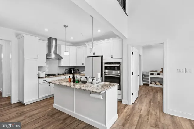 a kitchen with kitchen island granite countertop a sink stainless steel appliances and cabinets
