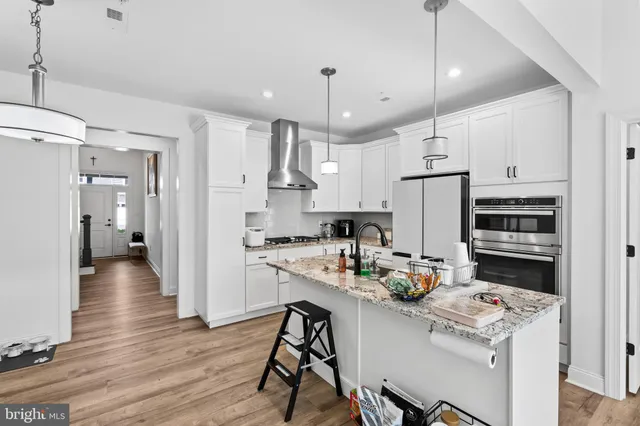 a kitchen with refrigerator cabinets and wooden floor