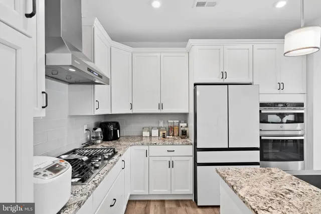 a kitchen with stainless steel appliances granite countertop a stove a refrigerator and a stove