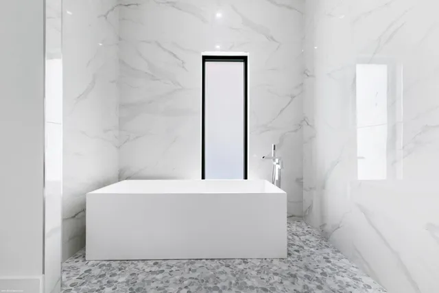 a front view of a house with a fountain and potted plants