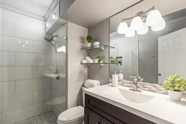 a bathroom with a sink a toilet and shower