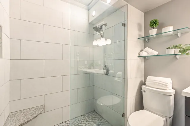 a view of a room with a ceiling fan and carpet