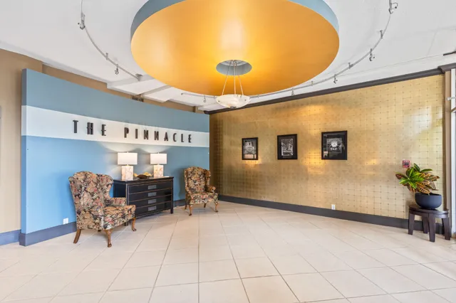 a living room with furniture a floor to ceiling window and potted plants