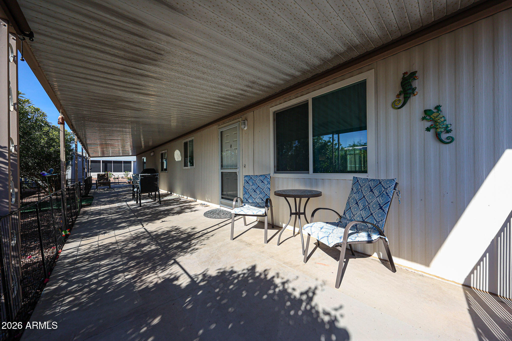 3104 East Broadway Road, Unit 216 Mesa, AZ 85204 - Photo 37 of 37 a view of a patio with table and chairs potted plants and floor to ceiling window