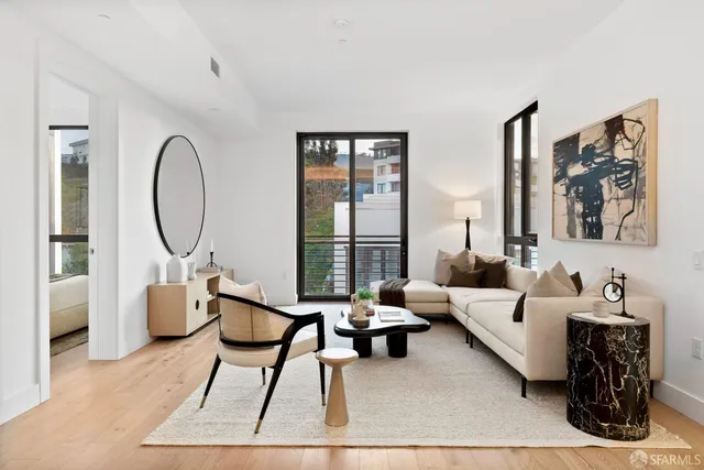 a living room with furniture a large window and a chandelier