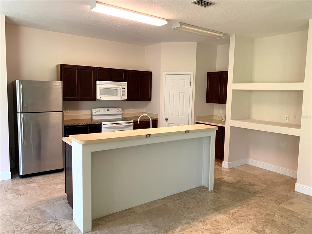 963 North Jacks Lake Road Clermont, FL 34711 - Photo 14 of 28 a kitchen with stainless steel appliances a refrigerator sink and microwave