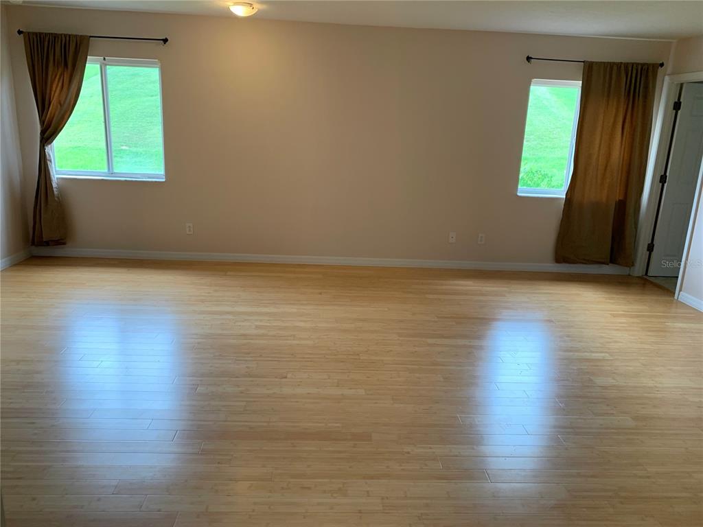 963 North Jacks Lake Road Clermont, FL 34711 - Photo 18 of 28 an empty room with wooden floor and windows