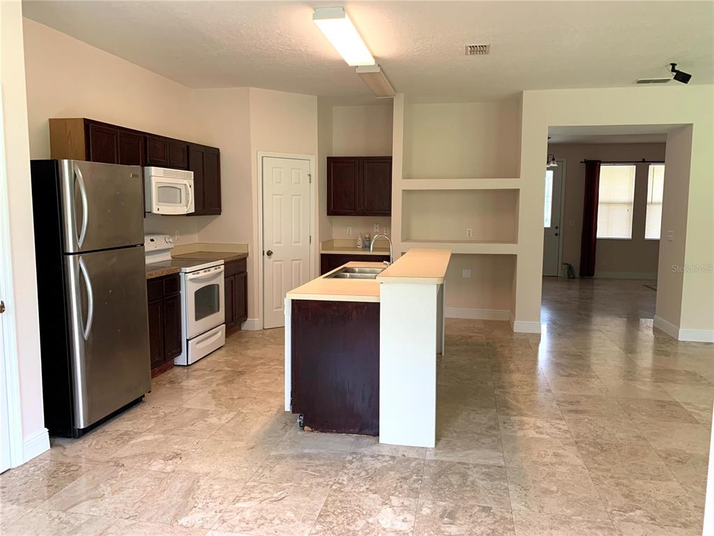 963 North Jacks Lake Road Clermont, FL 34711 - Photo 8 of 28 a kitchen with stainless steel appliances granite countertop a refrigerator a stove and a sink