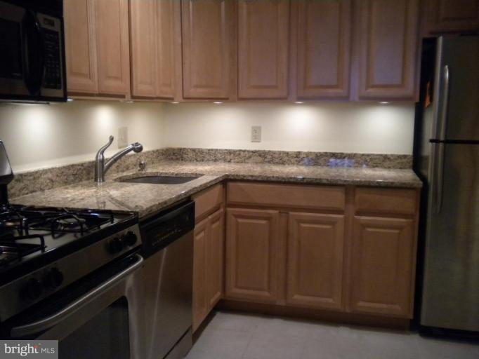 200 Cross Keys Road, Unit 58 Baltimore, MD 21210 - Photo 5 of 11 a kitchen with granite countertop stainless steel appliances a sink dishwasher and stove