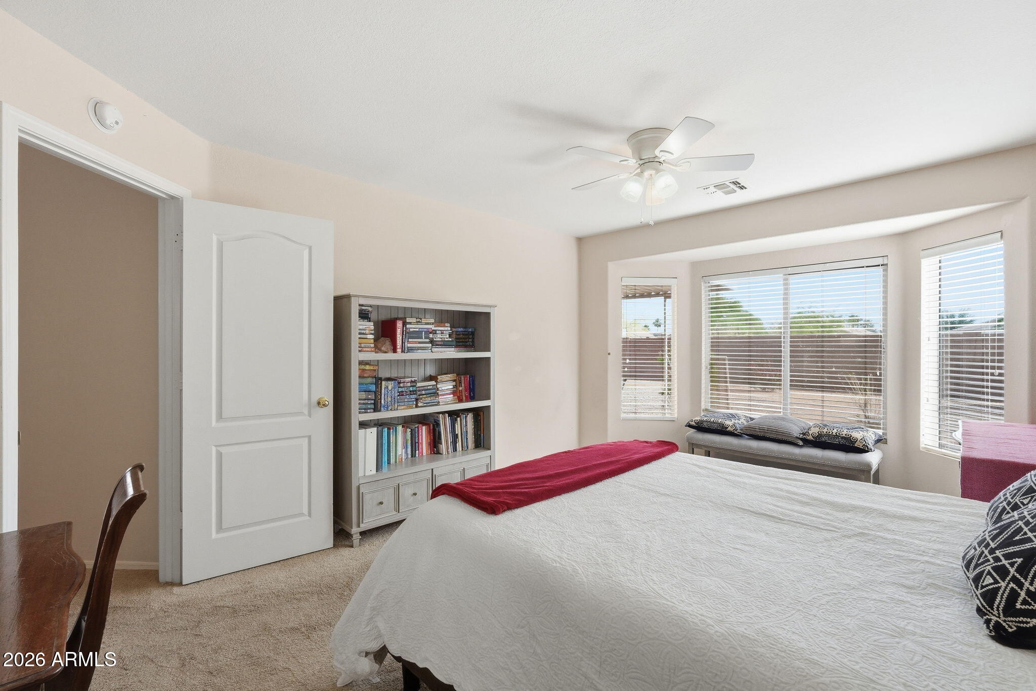 1405 West 15th Lane Apache Junction, AZ 85120 - Photo 18 of 33 a bedroom with a bed a large window and book shelf