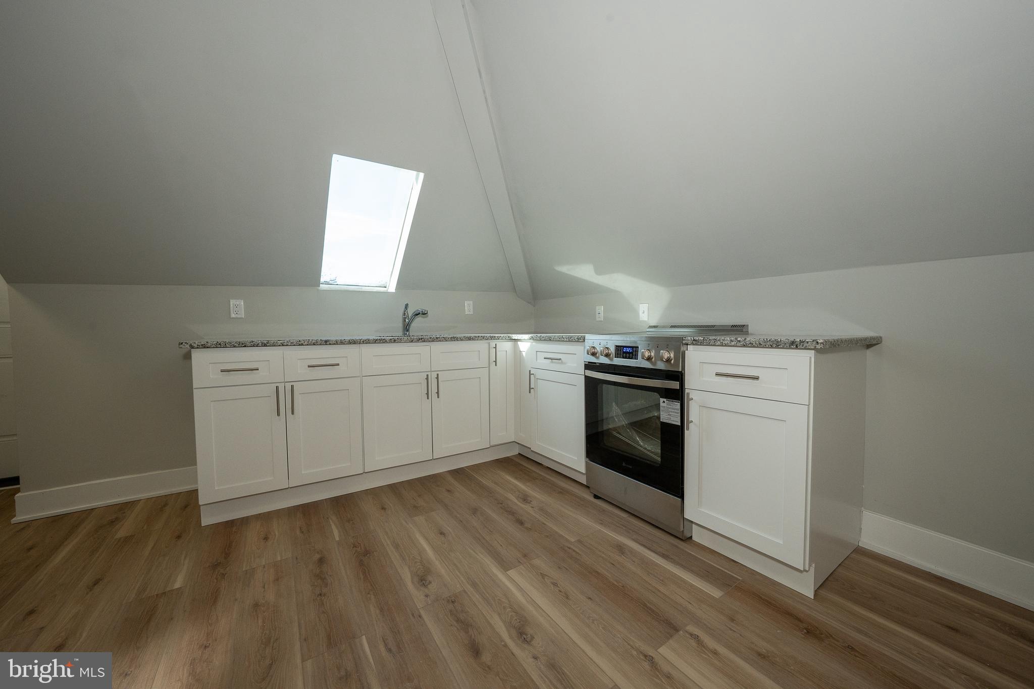 122 East 3rd Street, Unit 3 Pottstown, PA 19464 - Photo 15 of 35 a kitchen with a white cabinets and wooden floor