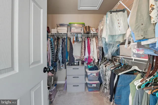 a view of walk in closet with clothes