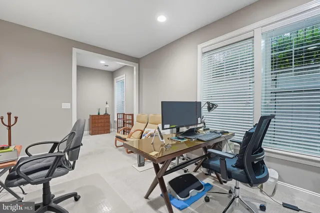 a view of a workspace with furniture and a window