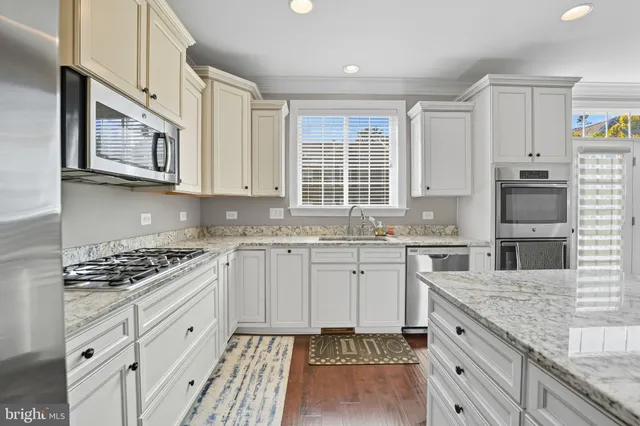 a kitchen with stainless steel appliances granite countertop a stove and cabinets