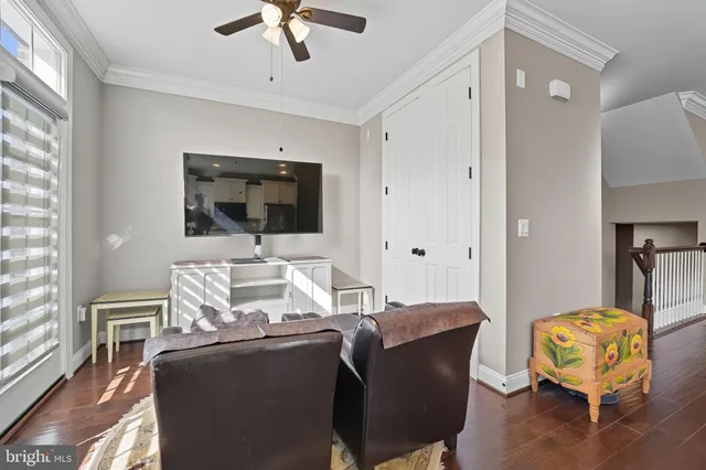 a living room with furniture a flat screen tv and a window