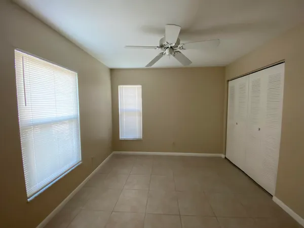 an empty room with windows and fan