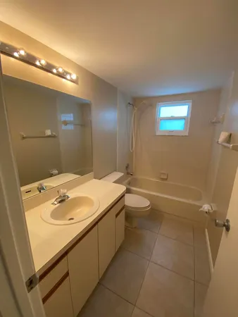 a bathroom with a granite countertop sink a toilet and tub