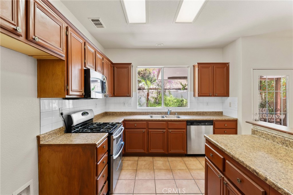 16200 Setting Sun Circle Riverside, CA 92503 - Photo 11 of 41 a kitchen with stainless steel appliances granite countertop a sink stove and cabinets