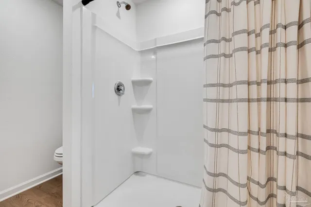 a white toilet sitting next to a white wall