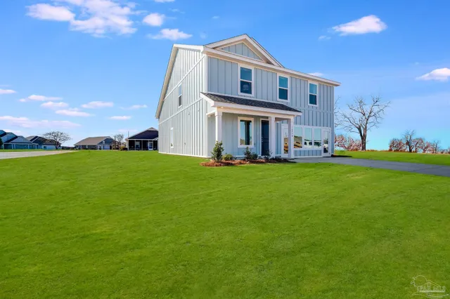 a view of a big house with a big yard and large trees