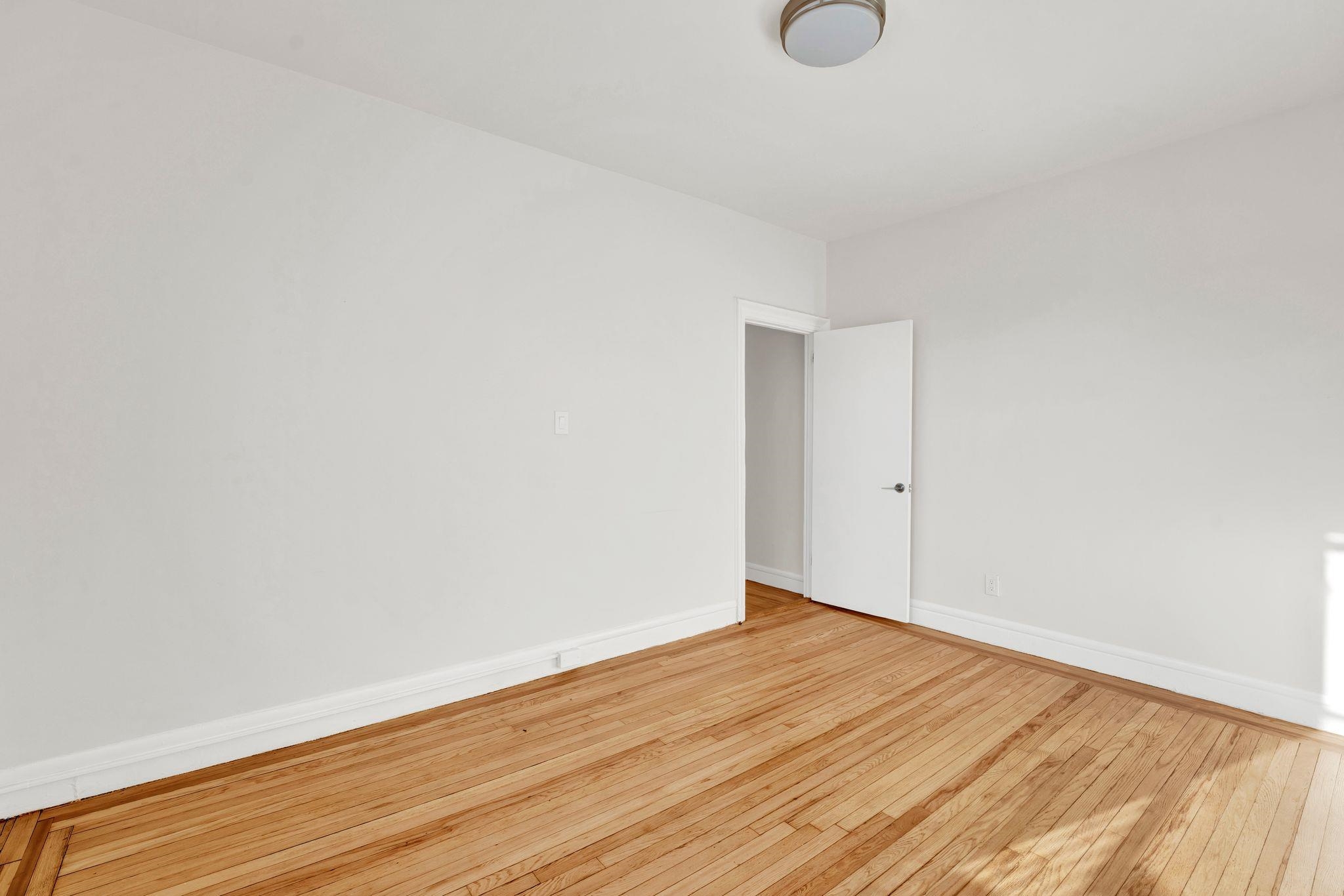 275 Harrison Avenue, Unit E5 Jersey City, NJ 07304 - Photo 12 of 17 a view of an empty room with wooden floor