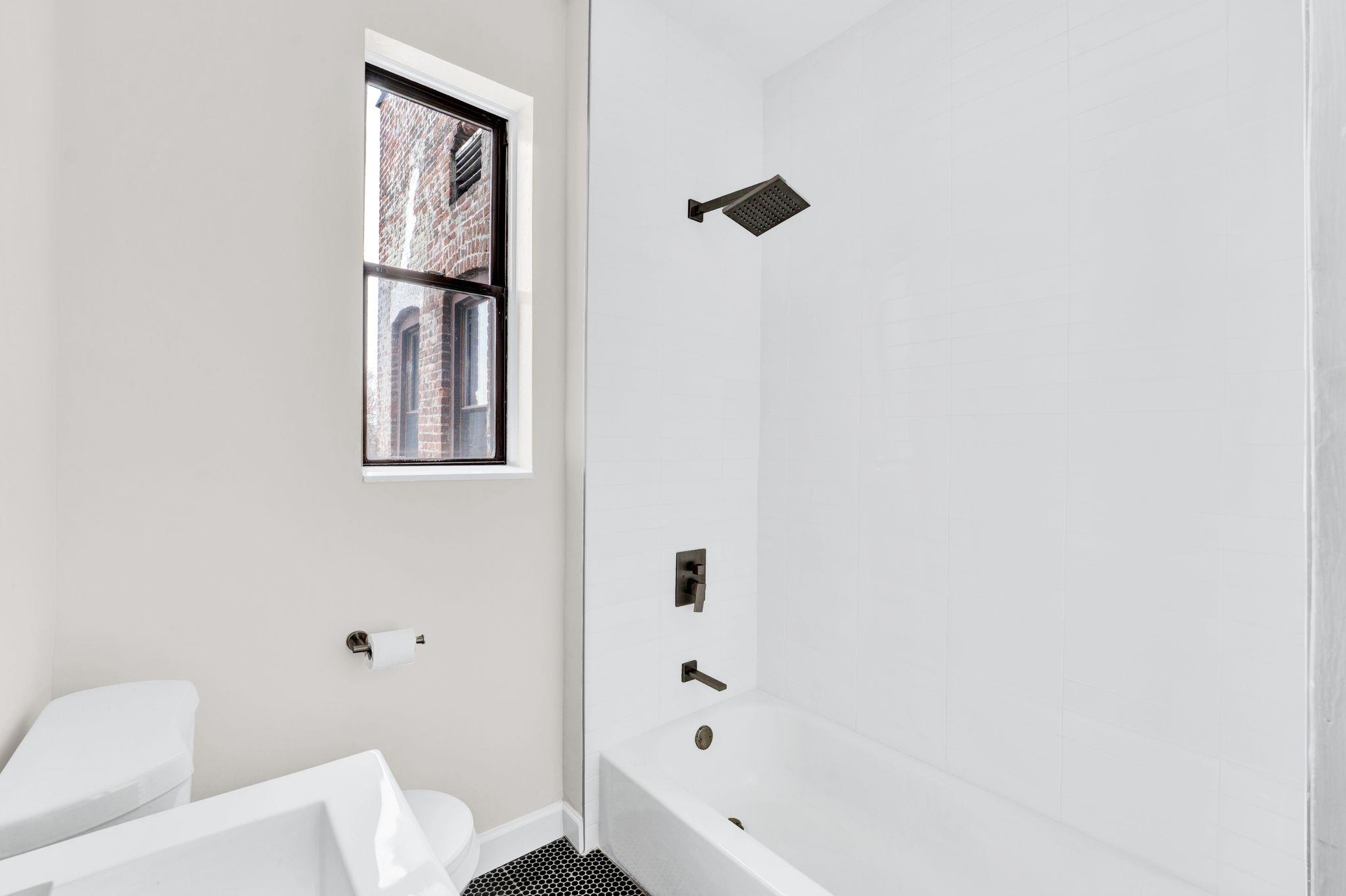 275 Harrison Avenue, Unit E5 Jersey City, NJ 07304 - Photo 14 of 17 a bathroom with a bathtub and shower