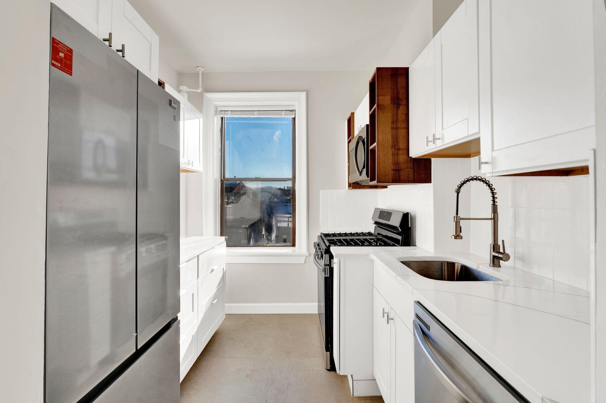275 Harrison Avenue, Unit E5 Jersey City, NJ 07304 - Photo 2 of 17 a kitchen with a sink a refrigerator and cabinets