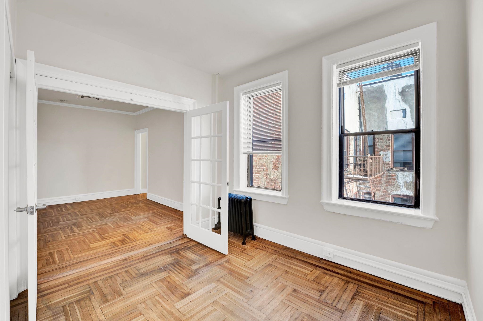275 Harrison Avenue, Unit E5 Jersey City, NJ 07304 - Photo 10 of 17 a view of an empty room with window and wooden floor