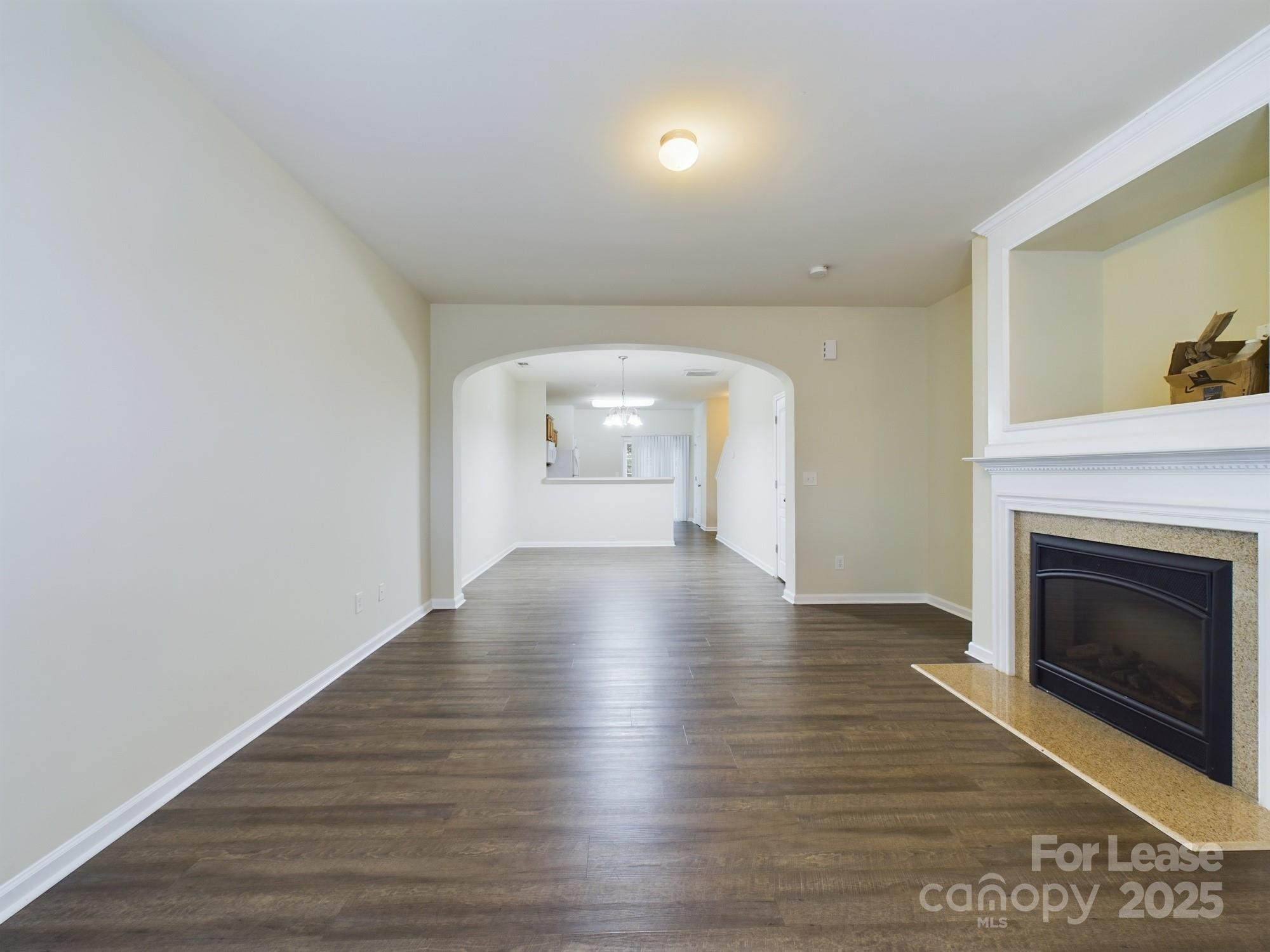 13564 Calloway Glen Drive Charlotte, NC 28273 - Photo 7 of 15 a view of empty room with wooden floor and fireplace