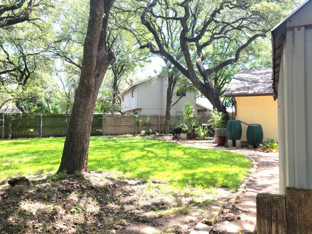 a view of backyard with large trees and a barn