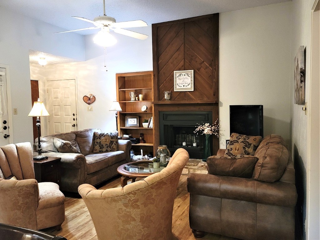 6904 Argonne Forest Cove, Unit A Austin, TX 78759 - Photo 12 of 25 a living room with furniture a large window and a fireplace