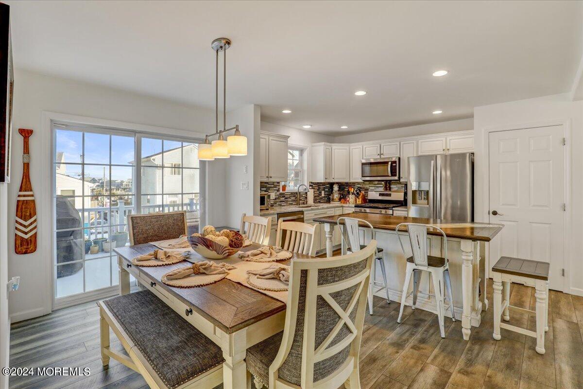 45 Vanard Drive Brick, NJ 08723 - Photo 11 of 52 a kitchen with stainless steel appliances kitchen island granite countertop a dining table chairs stove a refrigerator and cabinets