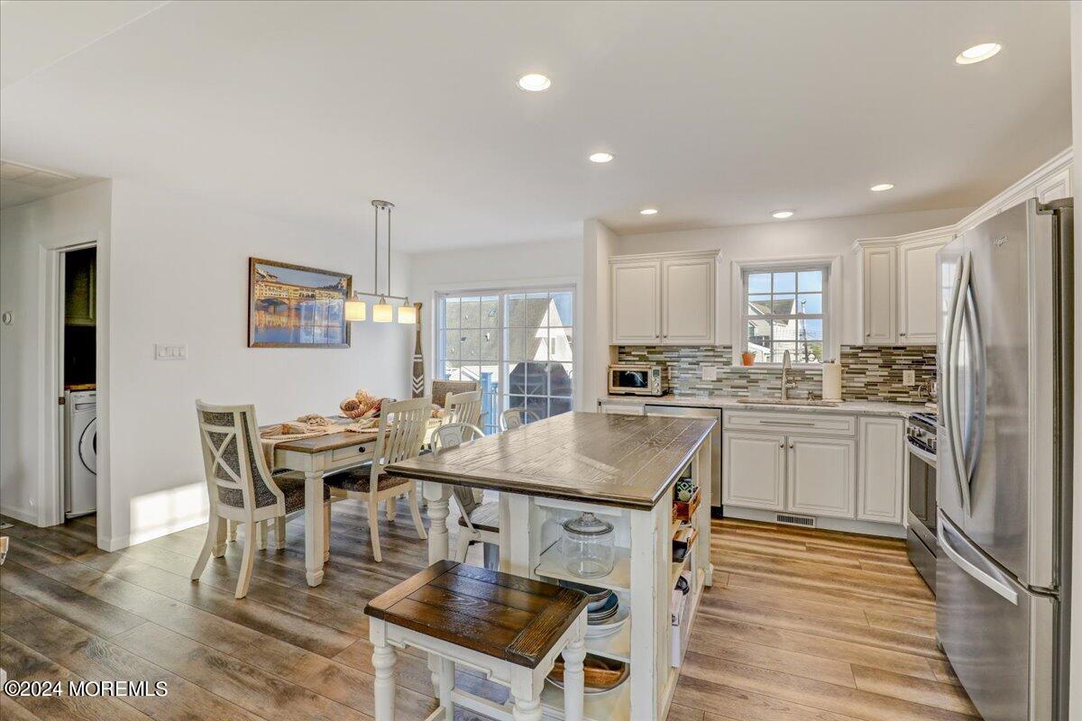 45 Vanard Drive Brick, NJ 08723 - Photo 14 of 52 a kitchen with stainless steel appliances granite countertop a stove a refrigerator a kitchen island a table and chairs