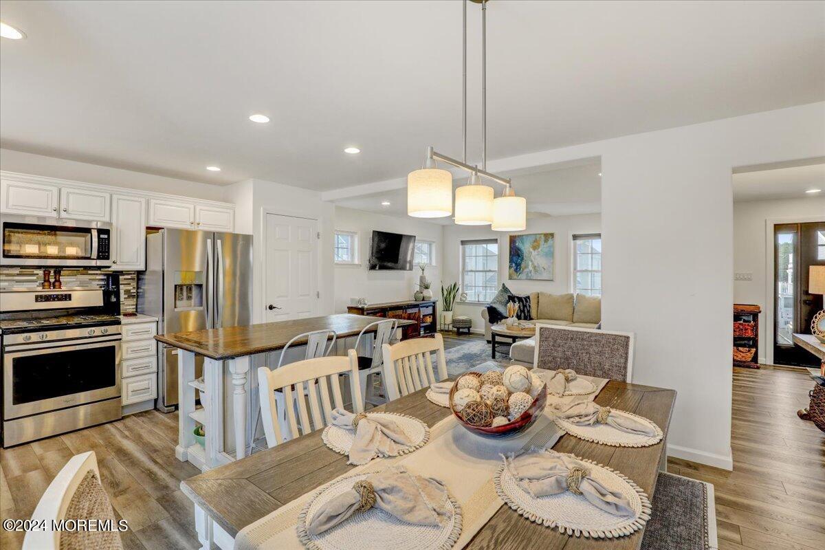 45 Vanard Drive Brick, NJ 08723 - Photo 16 of 52 a kitchen with stainless steel appliances wooden floor dining table and chairs