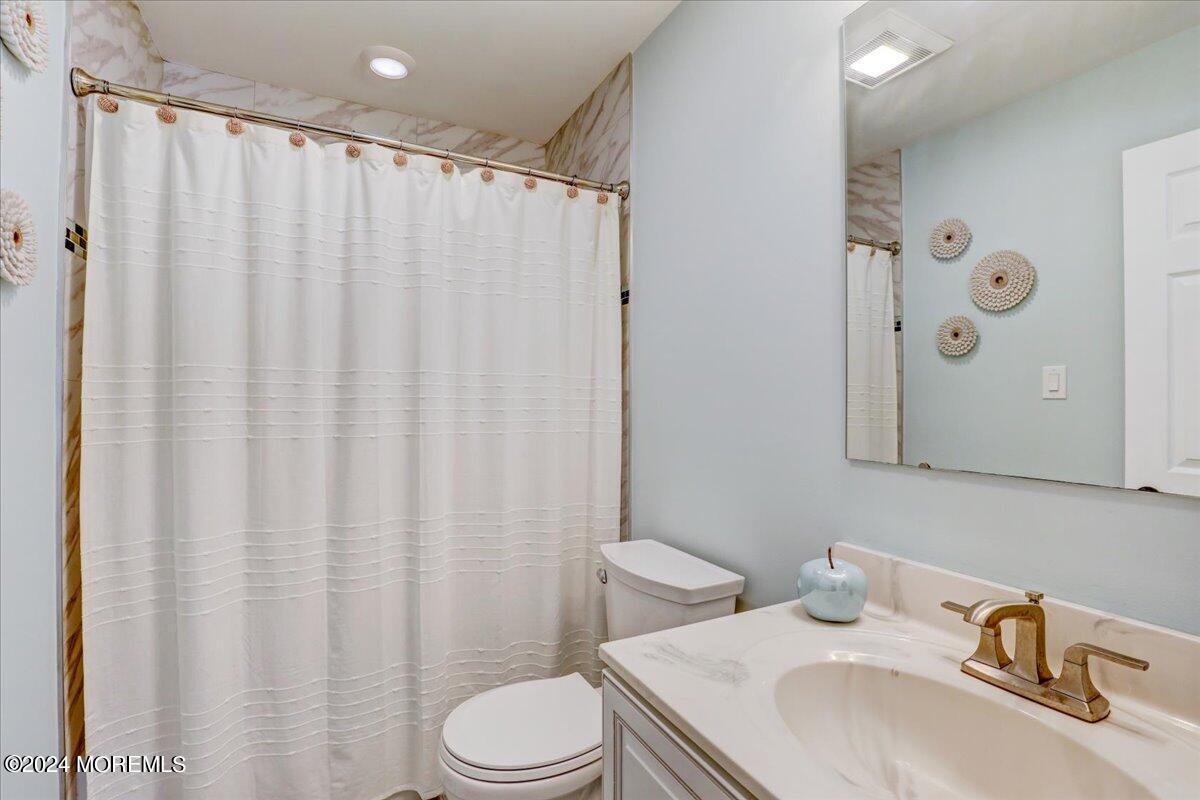 45 Vanard Drive Brick, NJ 08723 - Photo 21 of 52 a bathroom with a sink a toilet and shower curtain