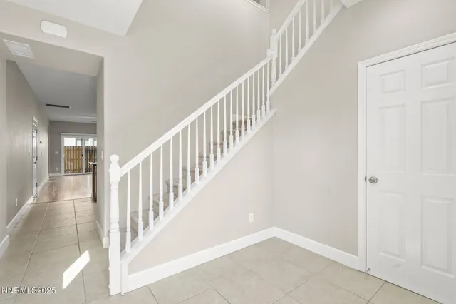 a view of staircase with railing and white walls