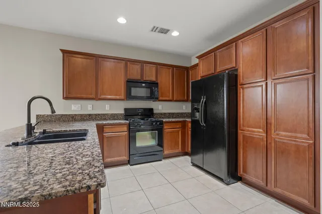 a kitchen with stainless steel appliances granite countertop a refrigerator and a stove top oven