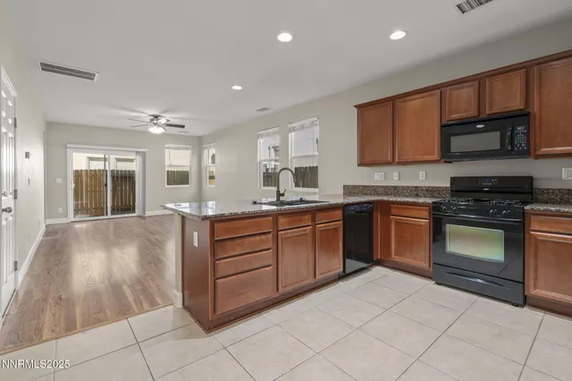a kitchen with granite countertop a stove top oven sink and cabinets