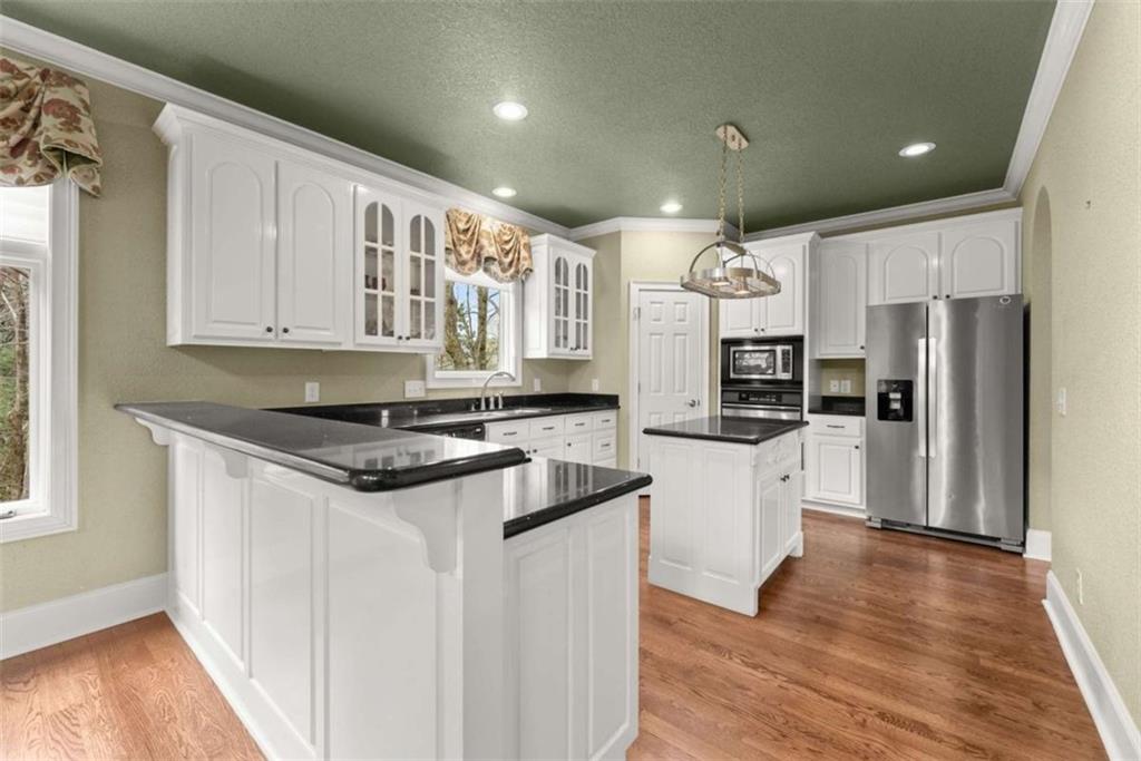777 Oak Pointe Drive Cleveland, GA 30528 - Photo 18 of 63 a kitchen with stainless steel appliances granite countertop a refrigerator a sink dishwasher a stove and white countertops with wooden floor