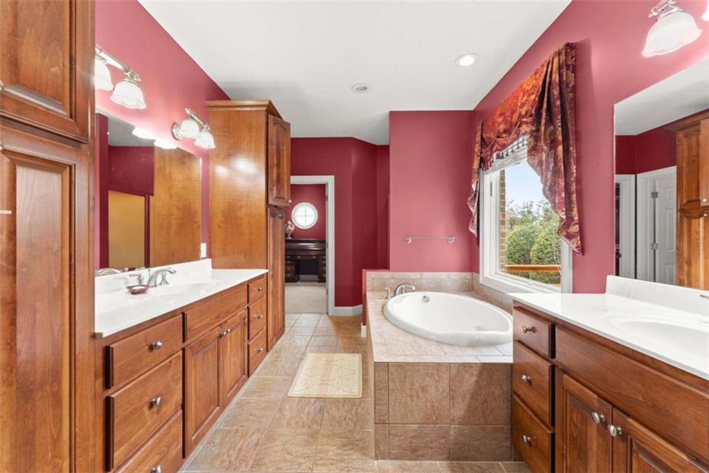 777 Oak Pointe Drive Cleveland, GA 30528 - Photo 30 of 63 a spacious bathroom with a sink a large mirror and a bathtub